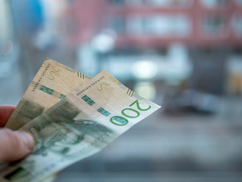 Person is paying with swedish money. 200 bill.