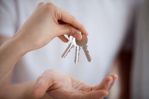 Broker realtor hand holding keys giving to new home buyer owner buying new house concept, customer renter making real estate deal, property ownership, mortgage loan investment contract, close up view